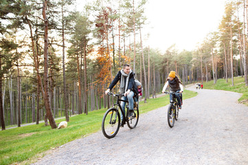 Naklejka premium Young family in warm clothes cycling in autumn park
