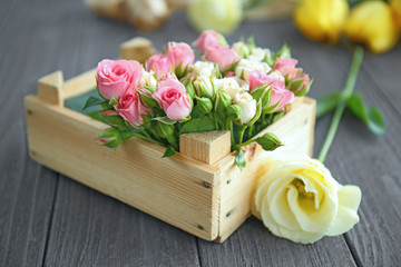 Beautiful flower composition in box on wooden background