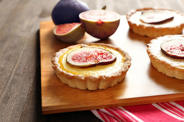 Tasty cake with figs on board on napkin, closeup