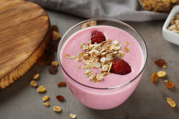 Healthy and tasty breakfast of berry milkshake with oatmeal on grey table