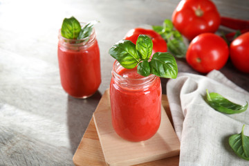 Glass jars with vegetable smoothie on wooden table