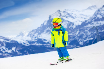 Fototapeta na wymiar Ski and snow fun. Child in winter mountains.