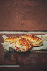 sweet buns with jam on a wooden background