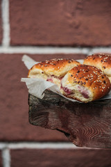sweet buns with jam on a wooden background