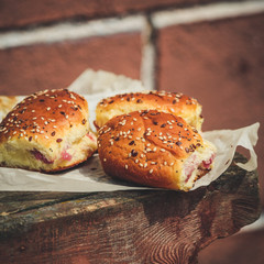 sweet buns with jam on a wooden background