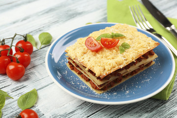 Portion of tasty lasagna on wooden table