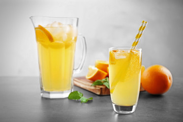 Glass of refreshing orange drink on table
