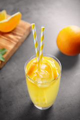 Glass of refreshing orange drink on table