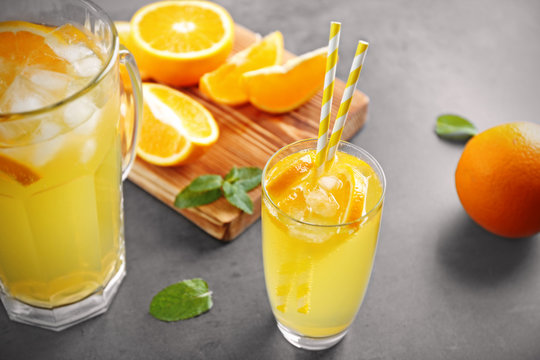 Glass of refreshing orange drink on table