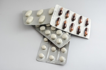 white pills in blister and brown capsules in blister
