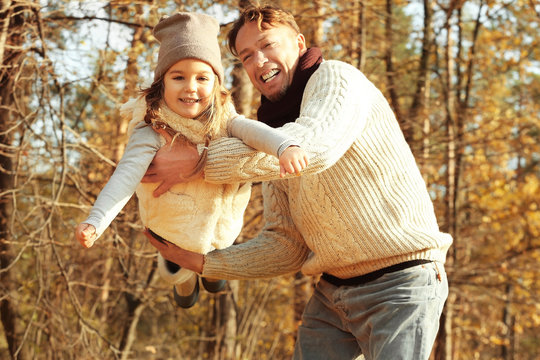 Father and daughter playing in beautiful autumn park