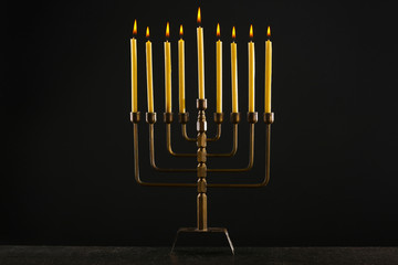 Menorah with candles for Hanukkah on black background