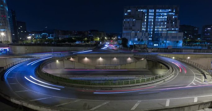 Cinemagraph of roundabout above highway. Night scene urban traffic, of Barcelona, underground traffic in motion and static traffic surface.Time Lapse - Trail effect - Long Exposure - Fixed plane.