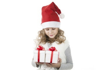 little girl in a Christmas cap with a gift box