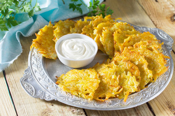 Homemade traditional potato pancakes, served with sour cream sau