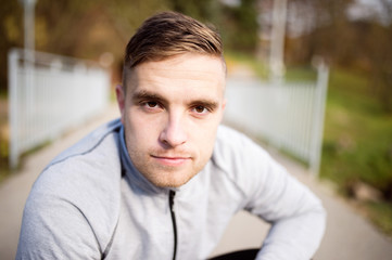 Young handsome hipster runner outside in sunny autumn nature