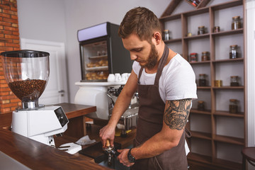 worker compressing grinds into the portafilter