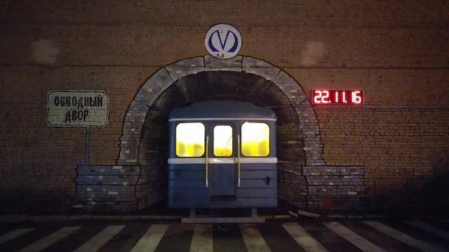 Underground carriage. Comic installation. Subway tunnel is all painted on a brick wall. The car is real.