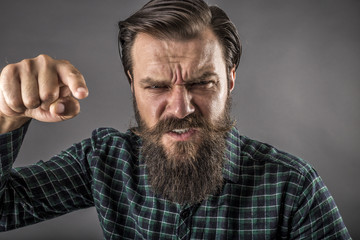 Obraz premium Closeup portrait of an angry bearded man threatening with his fi