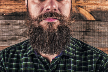 Closeup of a man beard and mustache over wooden background