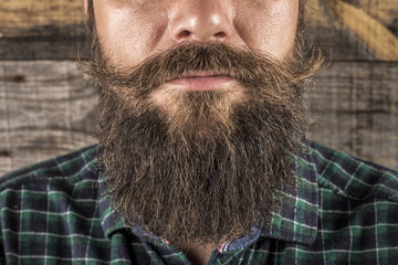 Closeup of a man beard and mustache over wooden background