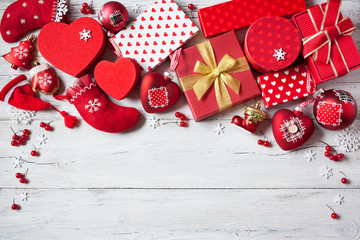 Christmas wooden background with presents in red boxes, socks and decorations
