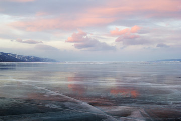 Pink sunset clouds and the ice surface of lake Baikal