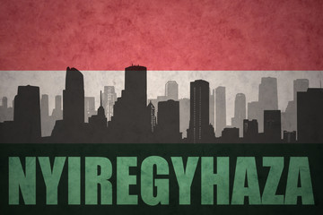 abstract silhouette of the city with text Nyiregyhaza at the vintage hungarian flag