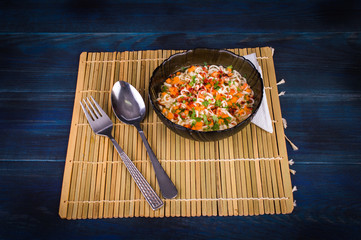 Noodles with condiments on a dark background