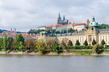 Naklejka na ściany i meble View on the Prague Castle from the river Vltava and on other historical buildings we tree lined walking path