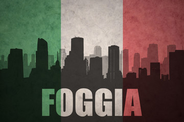 abstract silhouette of the city with text Foggia at the vintage italian flag