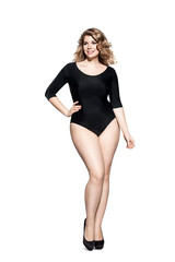 Beautiful fashionable plump woman in black body standing on a white background