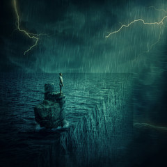 Lost man abandoned on a rock cliff island, in the middle of the ocean, in a stormy night. Adventure...
