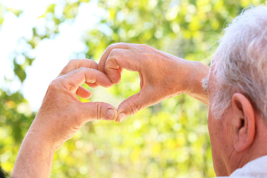 Hands Of Old Senior Showing Heart