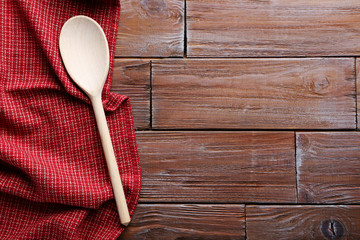 Red napkin and spoon on a brown wooden table