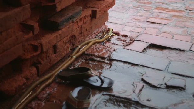 rain on brick pagoda structure and flip flops CLOSEUP