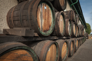 wooden barrels in the distillery folded in the yard in shelves