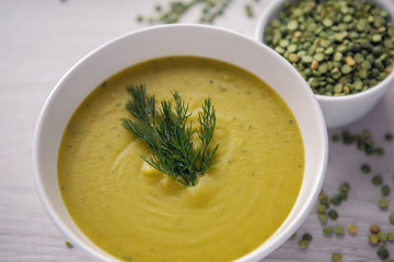 pea soup on a wooden table with an iron spoon