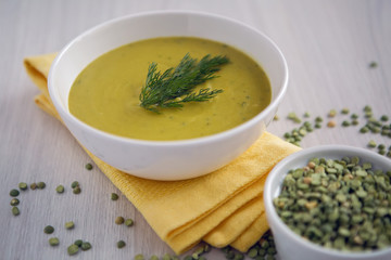 pea soup on a wooden table with an iron spoon