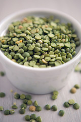 green peas in a white saucer on a white table