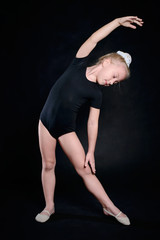 Fototapeta na wymiar Beautiful sport training girl portrait in leotard in nhe black room. classic portrait of gymnastics girl