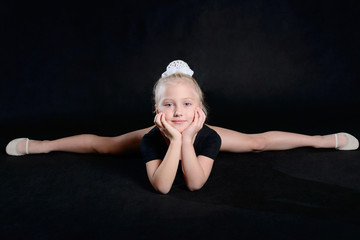 Beautiful sport training girl portrait in leotard in nhe black room. classic portrait of gymnastics...