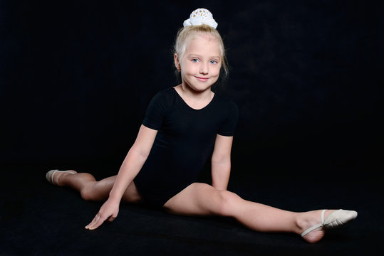 Beautiful sport training girl portrait in leotard in nhe black room. classic portrait of gymnastics girl