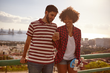Young couple on bridge with cell phone