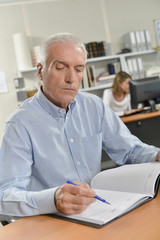 Senior office worker writing in his diary