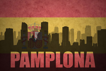 abstract silhouette of the city with text Pamplona at the vintage spanish flag