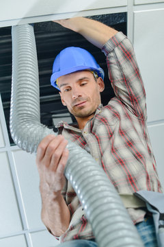 Man repairing ceiling ventilation