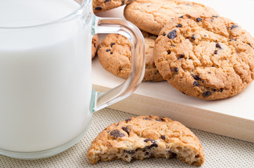 Glass cup with milk and oatmeal cookies with chocolate
