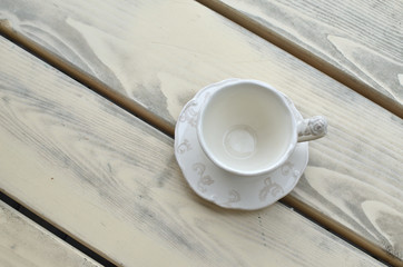 Fine porcelain cup on a park bench shot from above