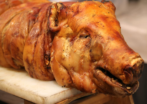 muzzle of the roasted pig on a spit in the butcher